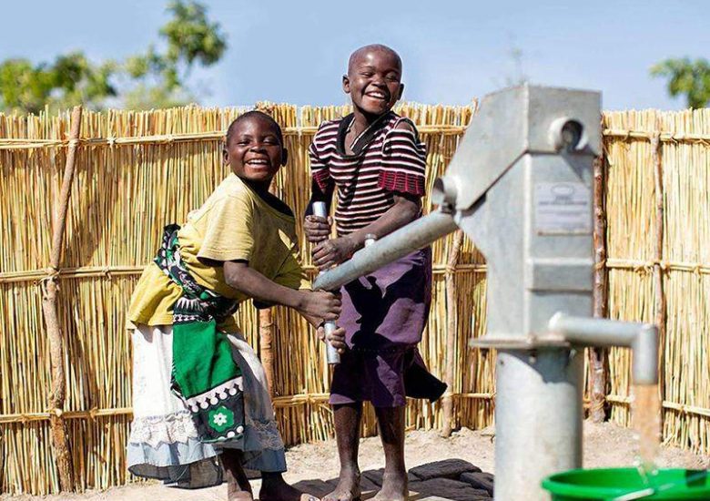 Two children are playing with a water pump.