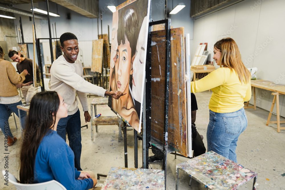 A group of people in a room with paintings.