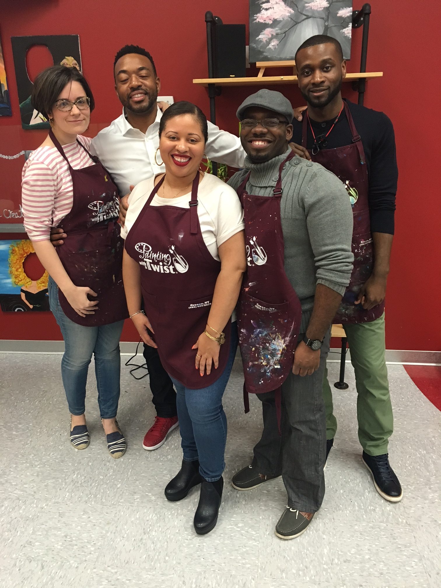 A group of people standing in aprons posing for the camera.