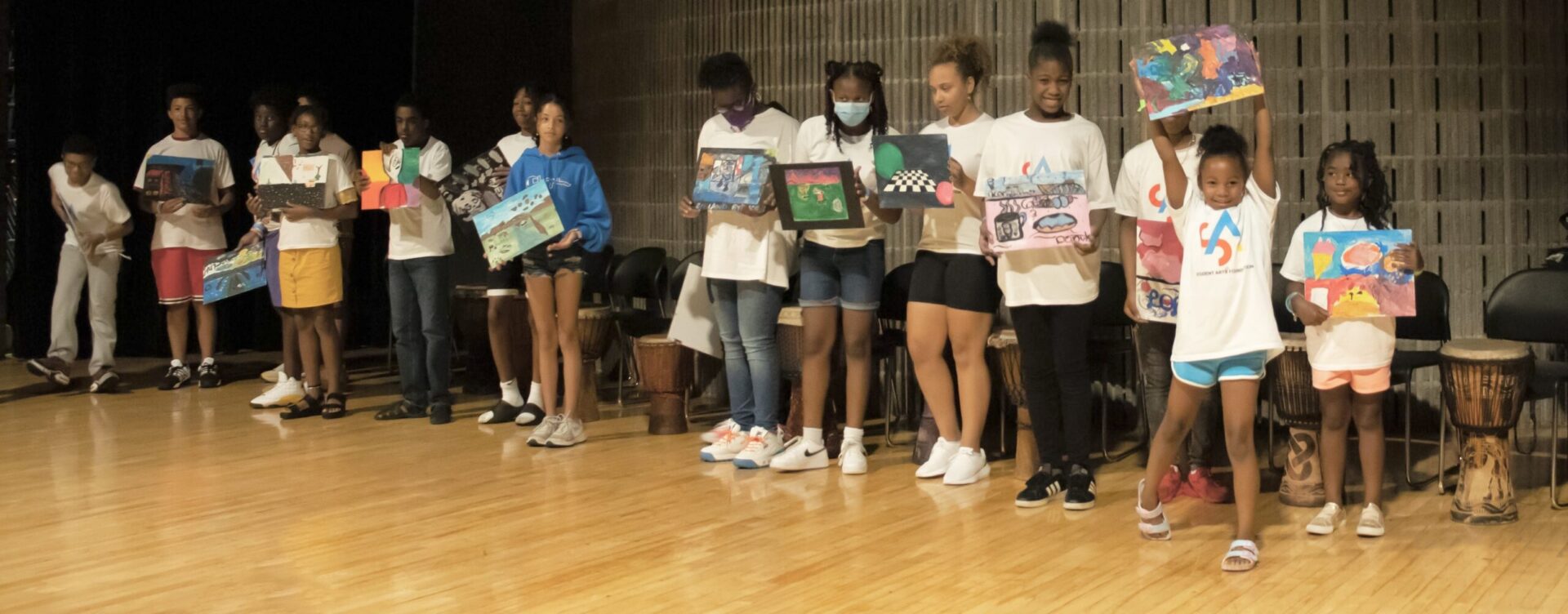 A group of young people holding up boxes.
