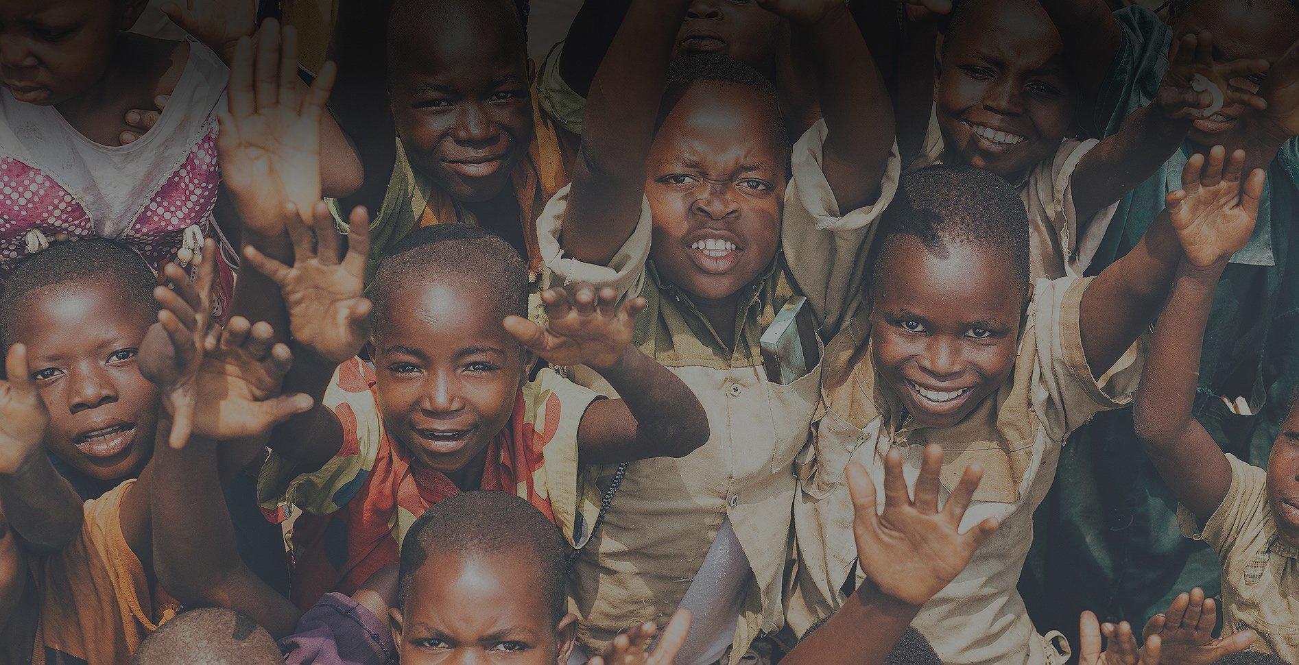 A group of children with their hands in the air.